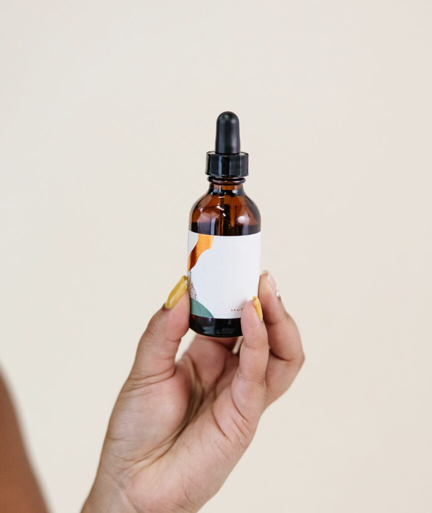 Hand holding essential oil dropper bottle.