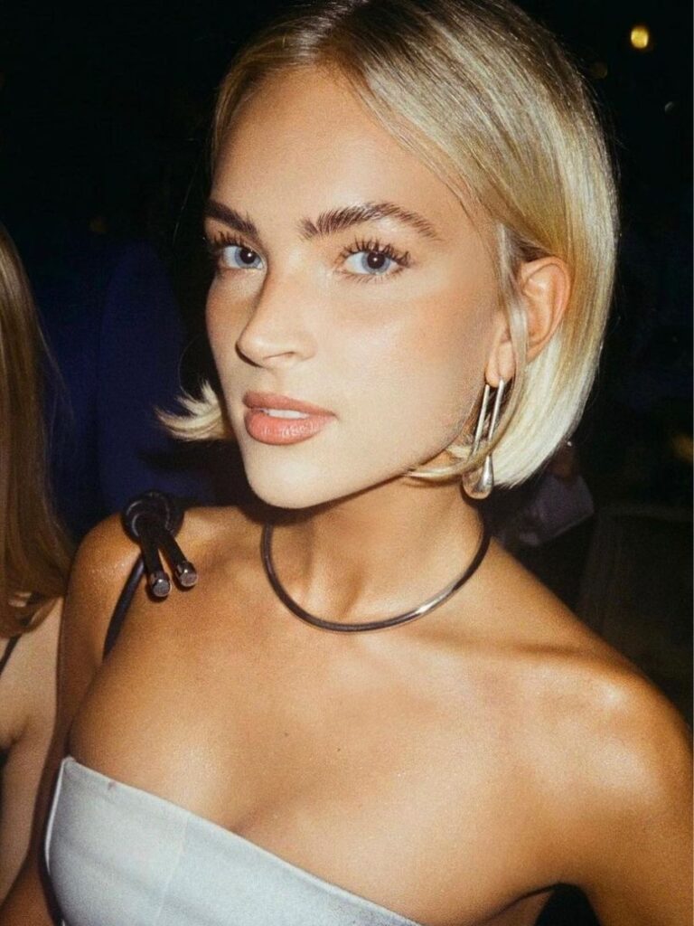 Blonde woman with hoop earrings at social event.